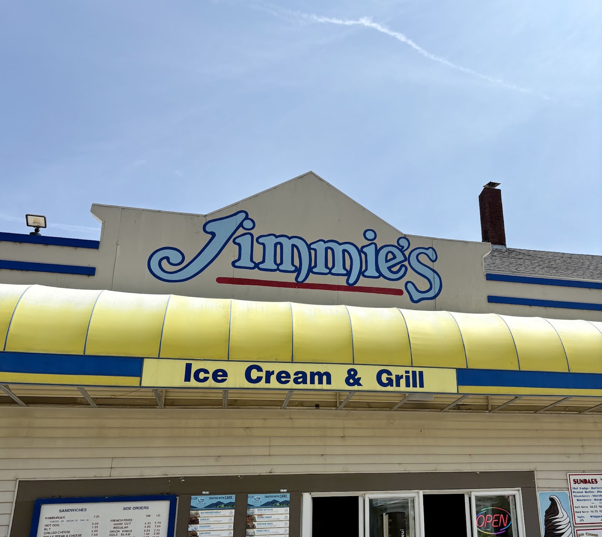 Jimmie’s storefront: a blue hand-painted sign reading Jimmie’s over a bright yellow awning and an Ice Cream & Grill sign.